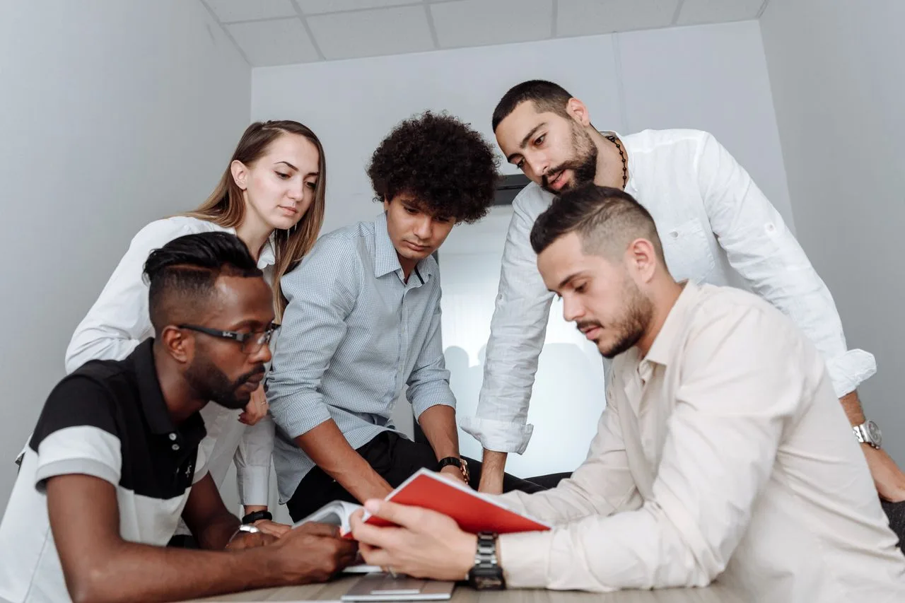 Colleagues gathered around a table reviewing a document