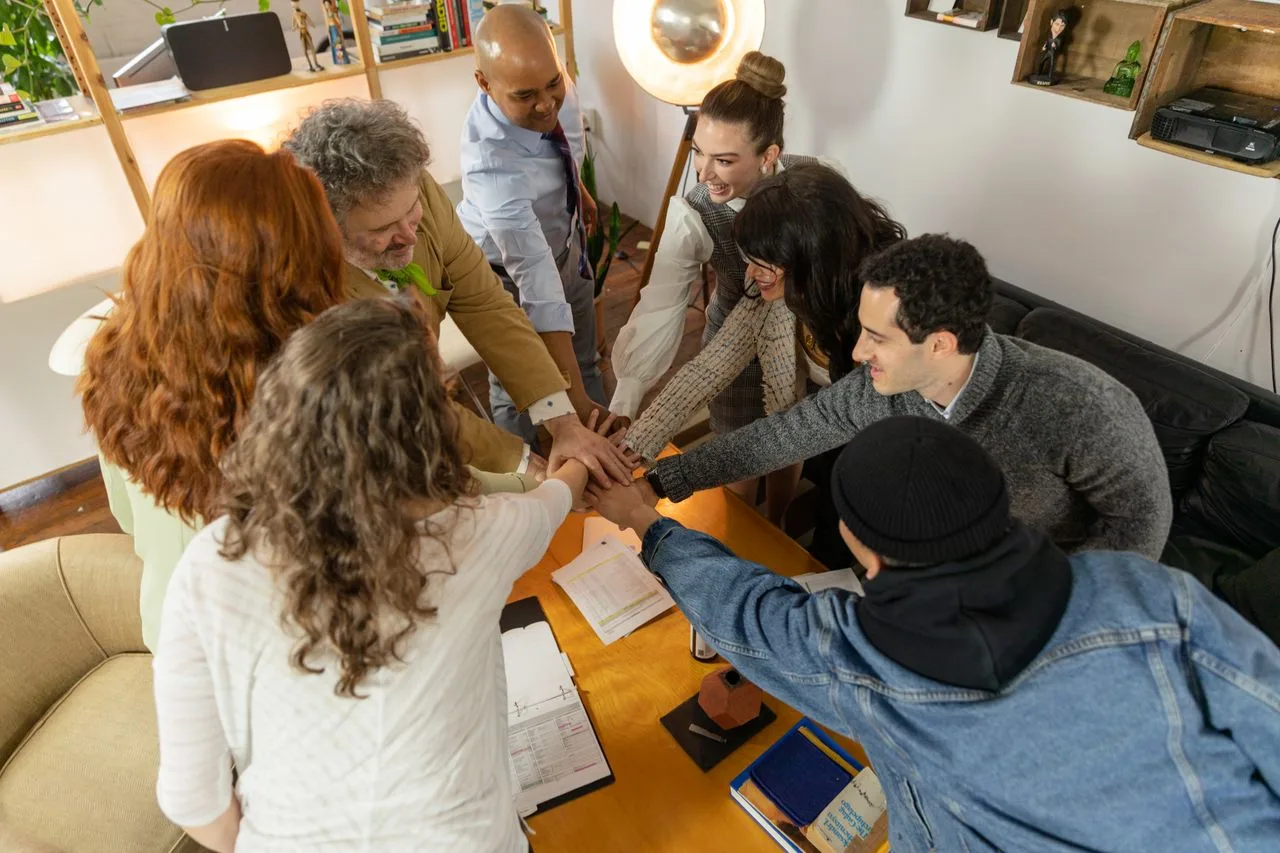 An overhead view of coworkers collaborating around a wooden table
